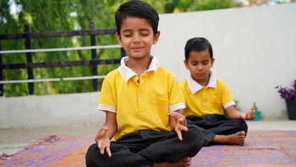 cute school boy doing yoga exercises or practicing at home. International yoga day celebration at home