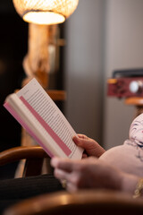 old woman spends time alone at home reading a book and listening to music