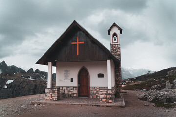 Fototapeta na wymiar Church in the middle of the Dolomites. Old church on a a rainy or cloudy day along a hiking trail in the alps.
