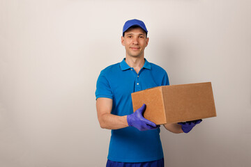 Portrait of handsome attractive cheerful delivery man holding card-board box. Express delivery service. Copy space.