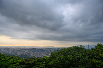 Rolling fast moving dark clouds. Orange sunset. At dusk, the view of Taipei City on a cloudy day.