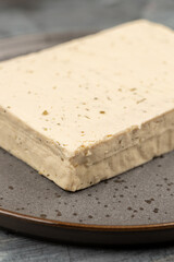 Tofu cheese on the plate above blue table background with copy space