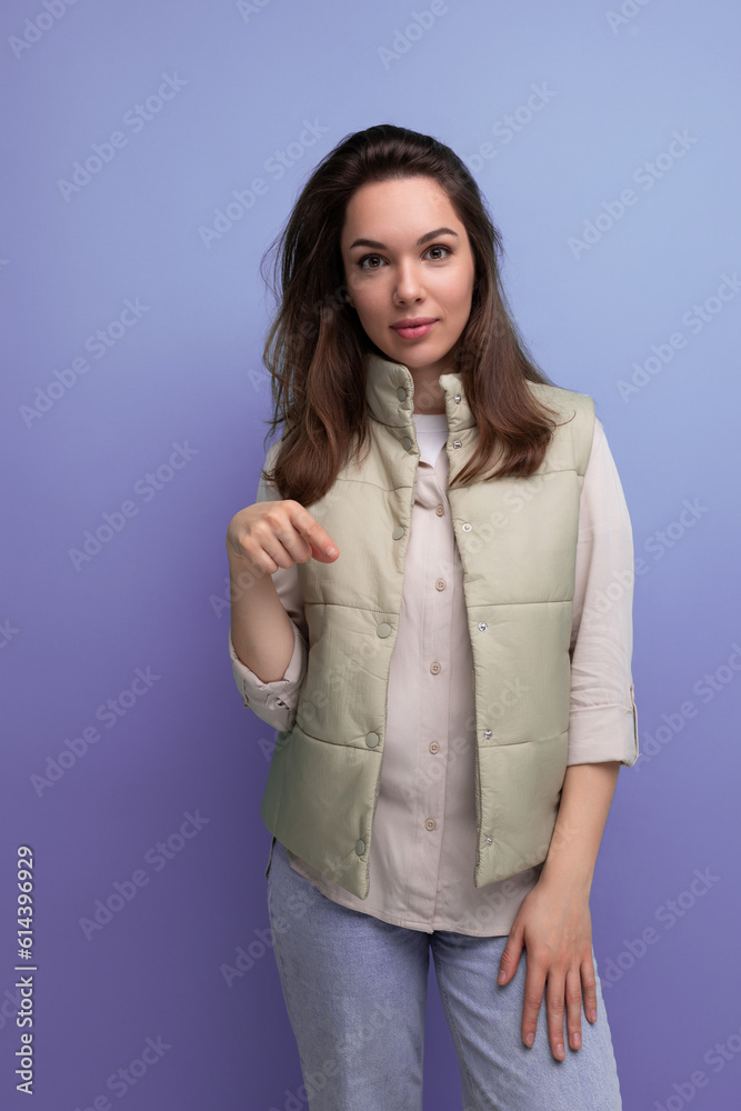 Wall mural optimist smiling brunette young woman in casual style in studio