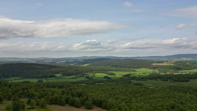 Aerial Deeside valley, green forests and hills with cloudy sky, 4K