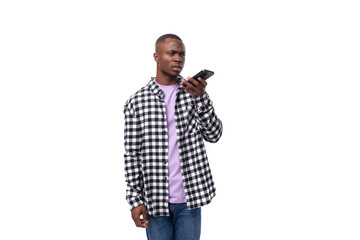 handsome young african man dressed in a plaid shirt chatting on the phone