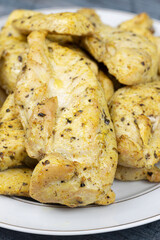Spiced chicken breasts served on the plate above blue background