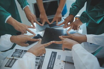 Mature doctors and young nurses stacking hands together at hospital. Close up hands of medical team stacking hands. Group of successful medical doctors and nurses stack of hands.