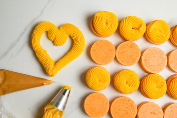 Set of colorful fresh halves of macarons decorated with tasty ganache top view.