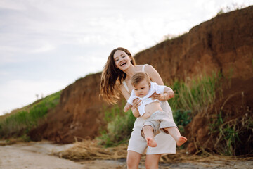 Mother with a child have fun  on the beach. Family, childhood, active lifestyle concept.