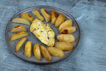 Fried Chicken breasts with potatoes on the plates above blue background