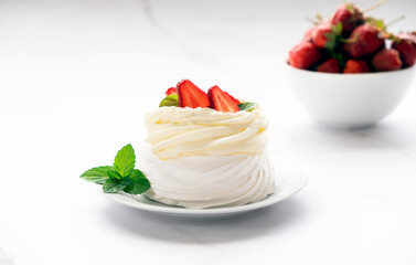 Pavlova meringue cake with fresh strawberry and whipped cream mascarpone with mint leaf decoration. Recipe of traditional dessert Anna Pavlova. Homemade pastry.