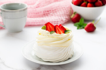 Homemade Pavlova meringue cake with fresh strawberry and whipped cream mascarpone with mint leaf decoration. Recipe of traditional dessert Anna Pavlova. Homemade pastry.