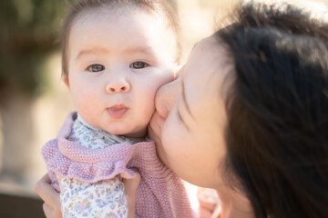 pure joy as a young Asian Chinese mother lovingly plays with her little baby girl, creating a lasting affection happiness bond -  motherhood beauty and childhood innocence