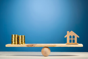 Property investment and house mortgage financial real estate concept. Wooden home and money coins...