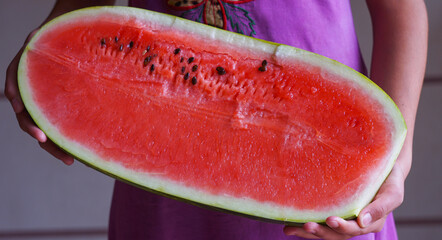 A big watermelon in the girl's hand