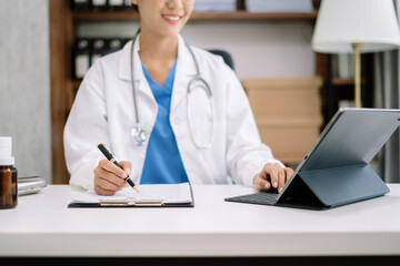 Female doctor working on desk with laptop computer and paperwork in the office. Medical and doctor concept.