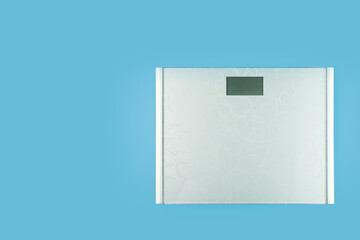 scales on a blue background, copy space, health and diet, obesity and weight loss