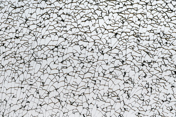 Macro closeup of a broken glass window. Cracks run throughout the glass, but no hole visible.
