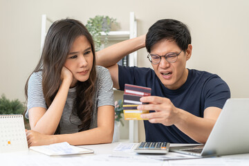 Stressed financial owe asian young couple love sitting stressed and confused hand calculate expense from credit card invoice, no money to pay, mortgage or loan. Debt, bankrupt or bankruptcy people.