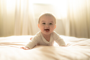 adorable and happy 5 months old baby girl gleefully discovers boundless joy while playfully...