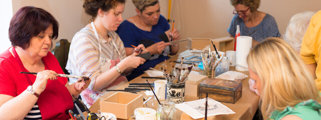 Women in art workshop making decoupage boxes	