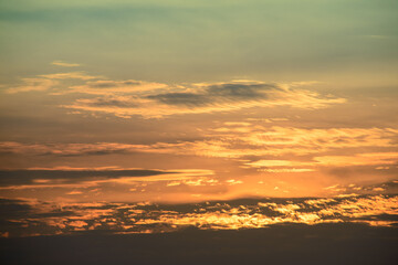 Row after row of neatly arranged white clouds. Beautiful orange-yellow sky at dusk.