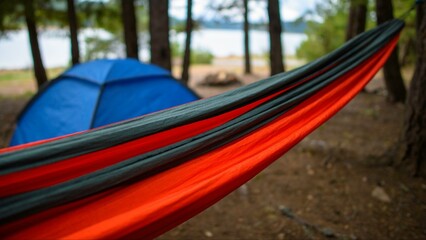 Nature's Oasis: Red Hammock Swinging Between Trees in a Serene Camping Ground with Breathtaking Natural Views