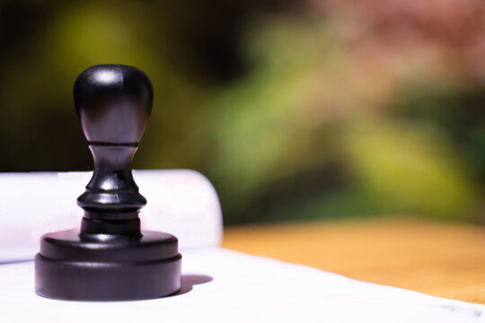 Rubber stamp placed on white paper, bokeh light background