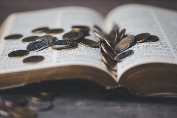 One tenth or tithe is basis on which Bible teaches us to donate one tenth of first fruit to God. Coins with Holy Bible. Religion donation and funding. Giving money, the symbol of Christianity donation