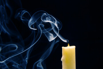 Smoke from an extinguished candle on a dark background. The concept of spirituality and the end of...
