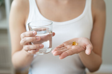 Nourishing the Body, Embracing Wellness: A Person Taking Fish Oil Supplements for Optimal Health...