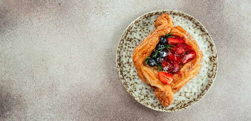 Fresh tasty puff pastry with sweet berries on a light background. Long banner format. top view