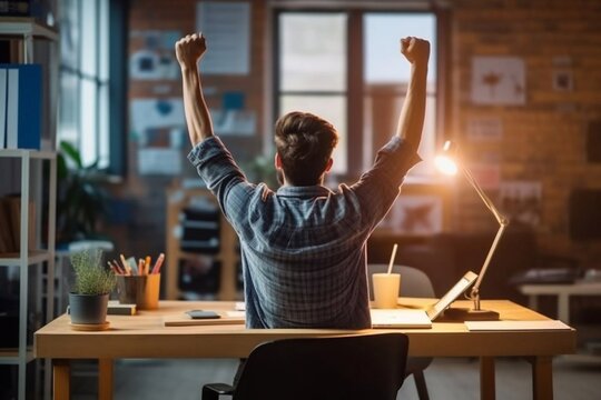 Success achieved Rear view of young man in casual wear gesturing while sitting at the desk in creative office Generative AI