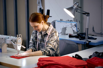 Textile cloth factory working process tailoring modern clothes, young beautiful caucasian woman at...