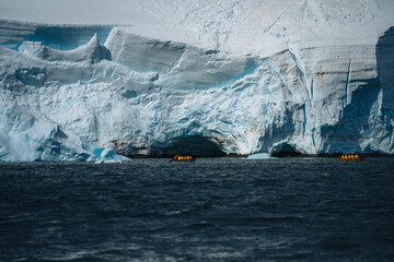Antarctic expedition, cruise passengers in yellow parkas ride in a Zodiac inflatable boat, very...