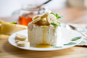 Portion of homemade milk curd with banana slices and honey