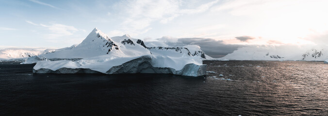 Beautiful snow-capped mountains against the sunset sky in Antarctica. Global warming and travel...