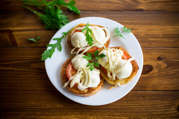 fried in batter sandwiches with tomatoes and mozzarella in a plate with herbs