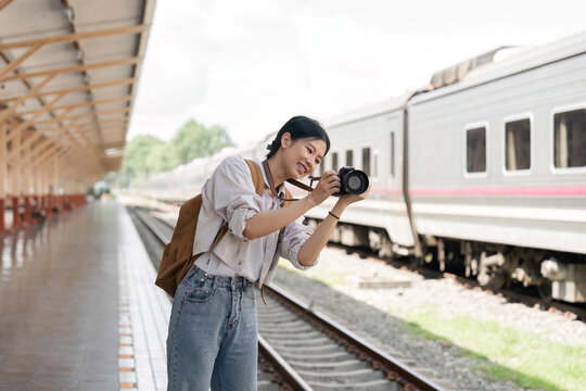 Traveler girl taking photo in train station