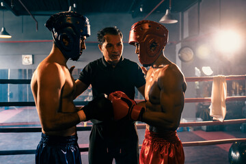 Boxer fighter with safety helmet or head guard face off with each other while referee explain rules...