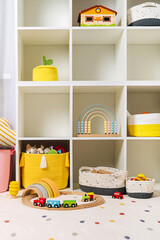 Children room with shelves and colorful storage baskets and boxes. Rainbow wooden toys. Space organizing at children s room. Interior design. Playroom