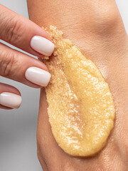 An orange smudge of the body scrub on a hand. Body smoothing scrub