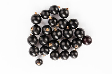 Ripe blackcurrant berries are scattered, isolated on a white background.