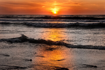 Fototapety  przepiękny zachód słońca nad morzem, oceanem - z falochronami, falami