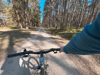 Fototapeta na wymiar First-person riding bike in the woods. man cyclist rides in the forest on a bike. first-person view. travel concept