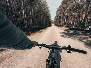 First-person riding bike in the woods. man cyclist rides in the forest on a bike. first-person...