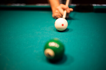 Young man playing snooker, aiming. for a good shot