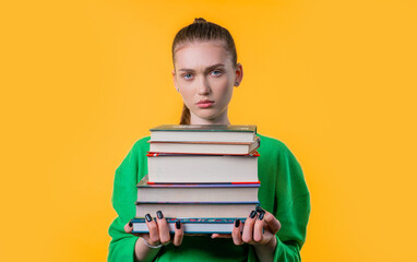 Lazy schoolgirl or student is dissatisfied with amount books homework on yellow