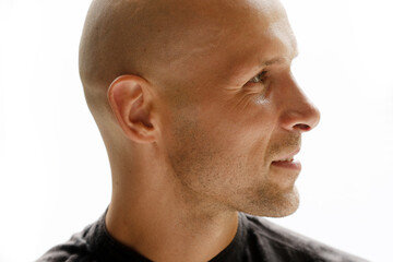Obraz premium A profile portrait of a bald man half smiling