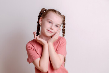 Pretty girl against a white wall, posing and smiling